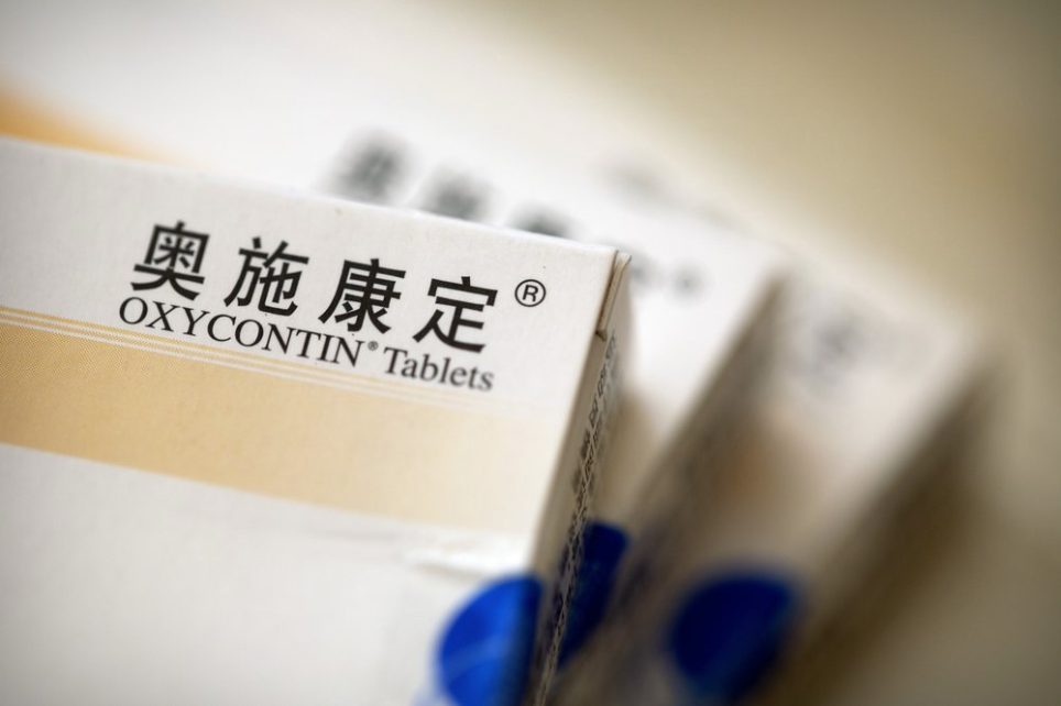 Boxes of OxyContin tablets sold in China sit on a table in southern China's Hunan province on Sept. 24, 2019. Representatives from the Sacklers' Chinese affiliate, Mundipharma, tell doctors that OxyContin is less addictive than other opioids — the same pitch that their U.S. company, Purdue Pharma, admitted was false in court more than a decade ago. Image by Mark Schiefelbein / AP Photo. China, 2019.