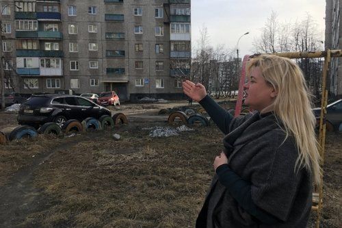 Anna Kireeva near some of the Soviet-era apartment blocks Murmansk, Russia. Image by Amy Martin. Russia, 2018.