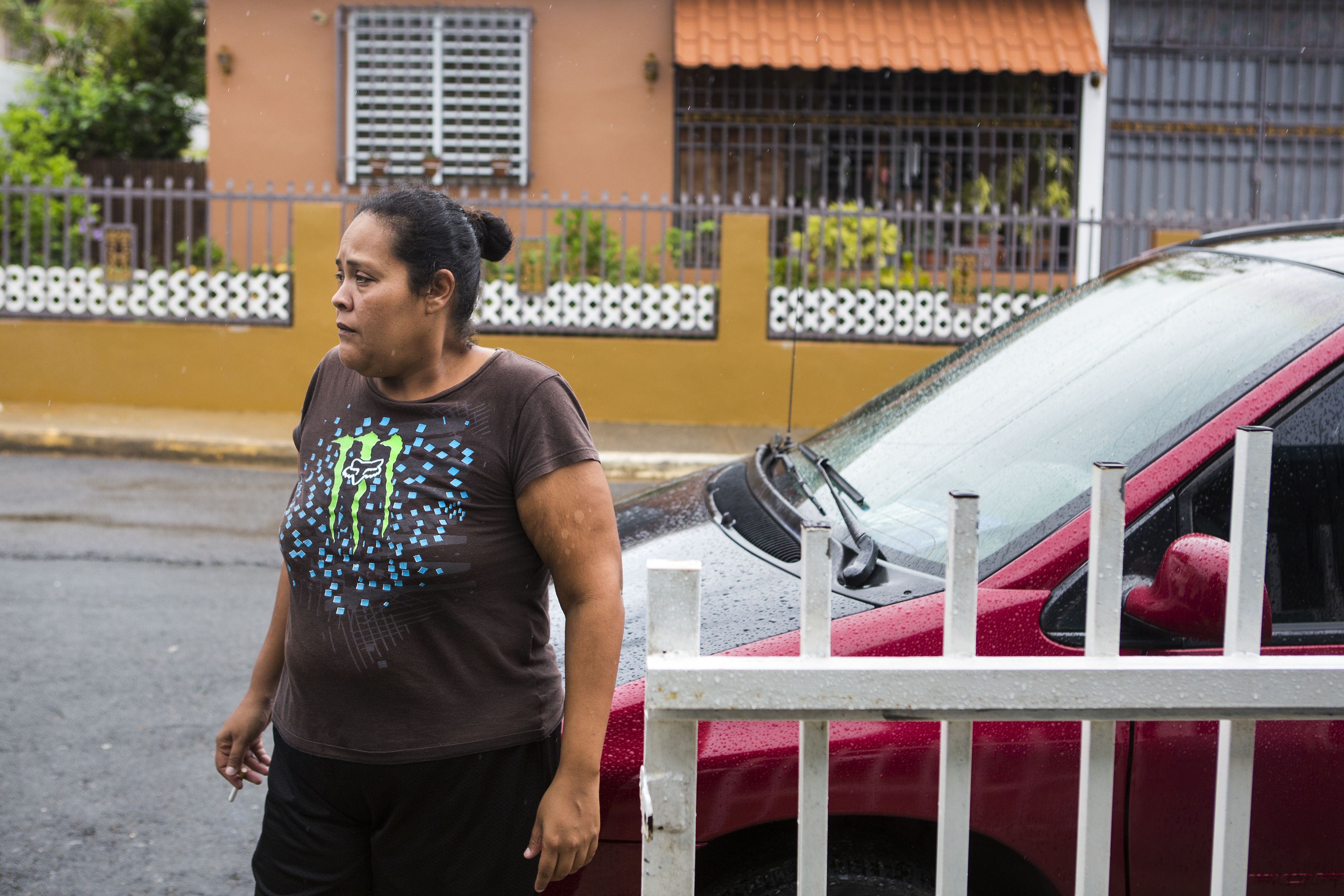 Karen Feliciano smokes a cigarette outside her home in Aibonito. Nearly 60 days after Hurricane Maria passed, the family is still without power—a necessity for her disabled son Kenny's health. Image by Ryan Michalesko. Puerto Rico, 2017.