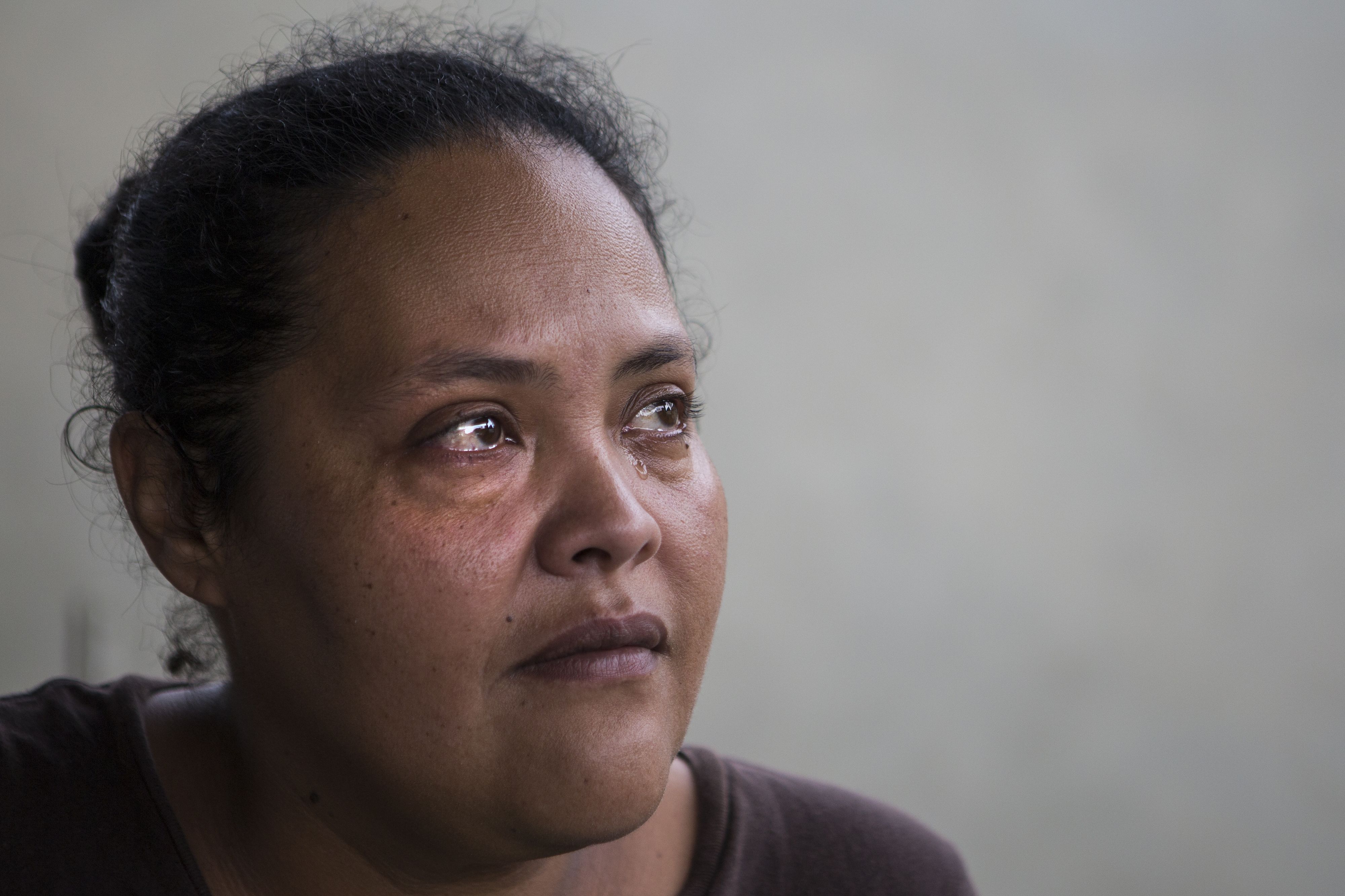 Karen Feliciano sheds a tear while seated on the porch of the family's home. Image by Ryan Michalesko. Puerto Rico, 2017.