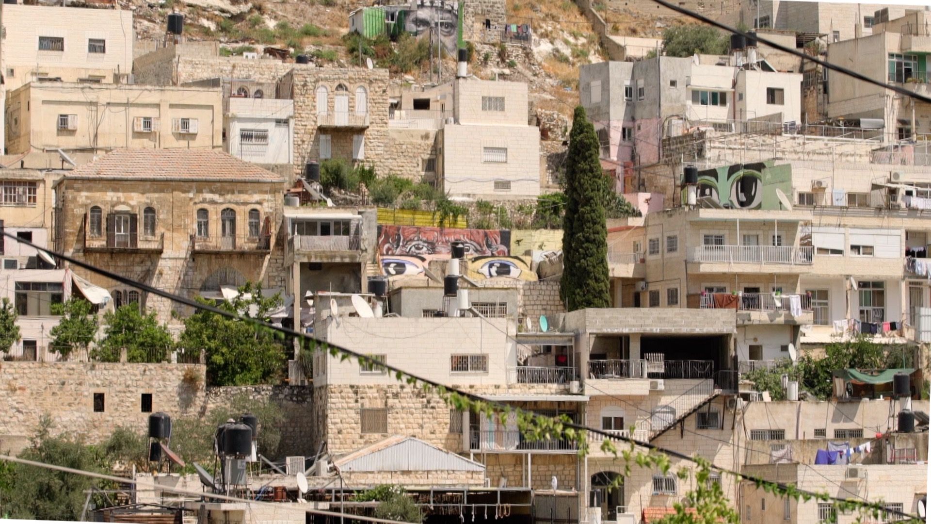 Murals of eyes look out from across the Wadi Hileh area in the Palestinian neighbourhood in Silwan. Image by BBC News Arabic.