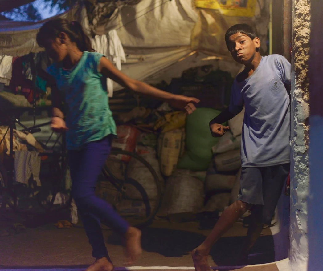 Suraj Malam, 21, suffers from cerebral palsy. Here, he is seen standing on his own and losing his sister's grip as she runs off.  Image by Rohit Jain. India, 2019. 