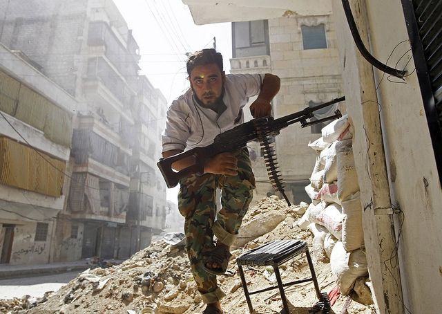 A Free Syrian Army fighter takes cover during clashes with Syrian Army in the Salaheddine neighbourhood of central Aleppo August 7, 2012. REUTERS/Goran Tomasevic courtesty Creative Commons. Syria, 2016.