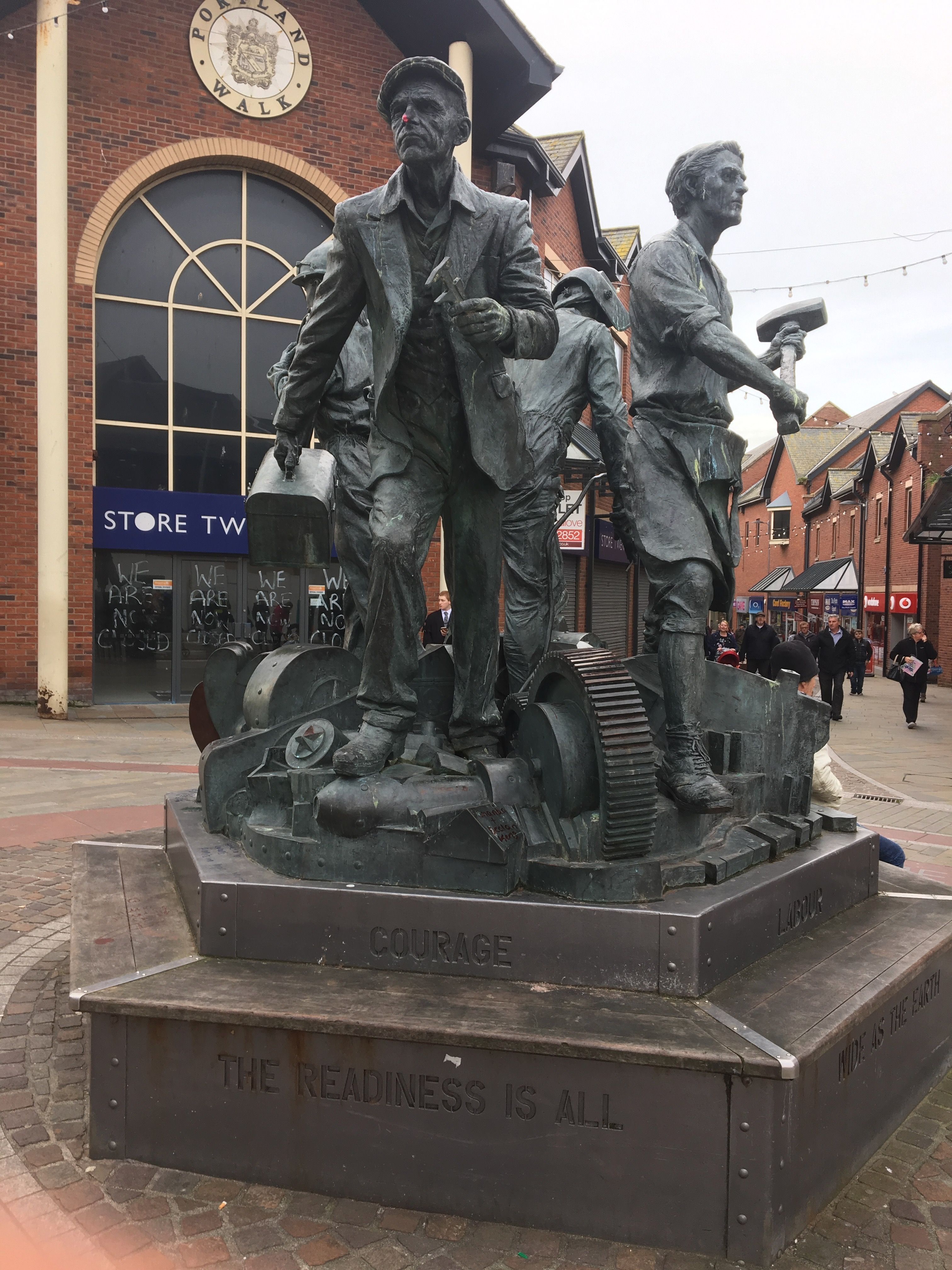 This monument to the heroic workers of the shipyard in Barrow was paid for by BAE Systems. It reads: "COURAGE. THE READINESS IS ALL". Image by Matt Kennard. United Kingdom, 2017.