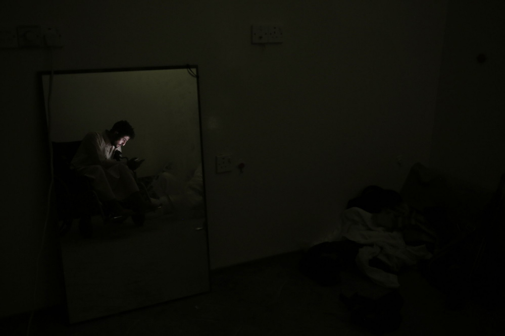 Anas al-Sarrari sits in his wheelchair during a power cut in his home in Marib. Image by Nariman El-Mofty for AP News. Yemen, 2018.