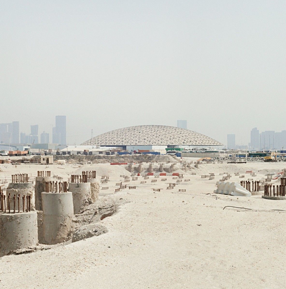 The Louvre Abu Dhabi dome and the site of the Guggenheim’s troubled project. Image by Knut Egil Wang. UAE, 2016.