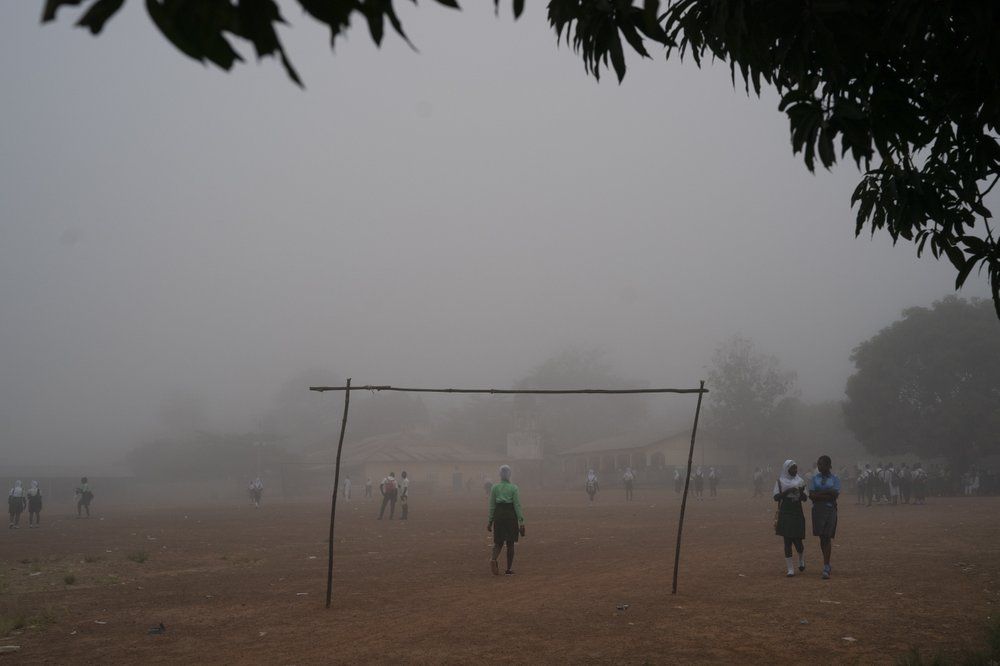 Students walks in the fog as they arrive at a secondary school in Koidu, district of Kono, Sierra Leone, Friday, Nov. 20, 2020. Image by Leo Correa/AP Photo. Sierra Leone, 2020.
