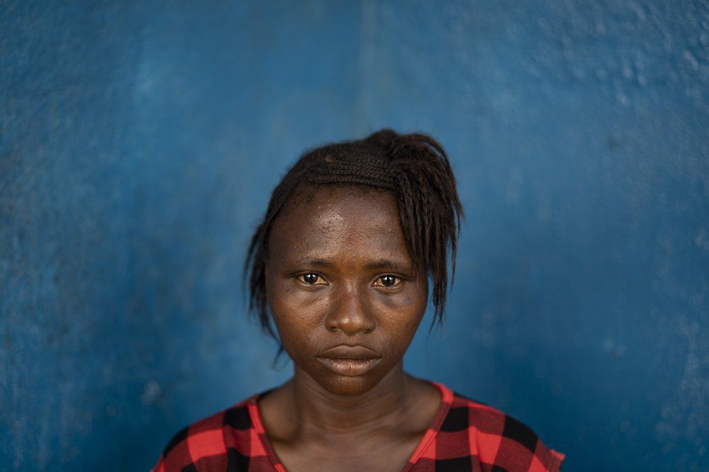 Kadiatu poses for a portrait in Lei chiefdom, district of Kono, Sierra Leone, Friday, Nov. 27, 2020. The 15-year-old she says her widowed mother pushed her into marriage during the pandemic because of financial hardship and because the teenager's prospects for a husband already were considered limited as she had gotten pregnant once before at 12. She can’t be sure just how much money was offered as a bride price: She was crying too hard at the ceremony to see straight. “I was not ready to get married. I wanted to learn something first,” she says. Image by Leo Correa/AP Photo. Sierra Leone, 2020.