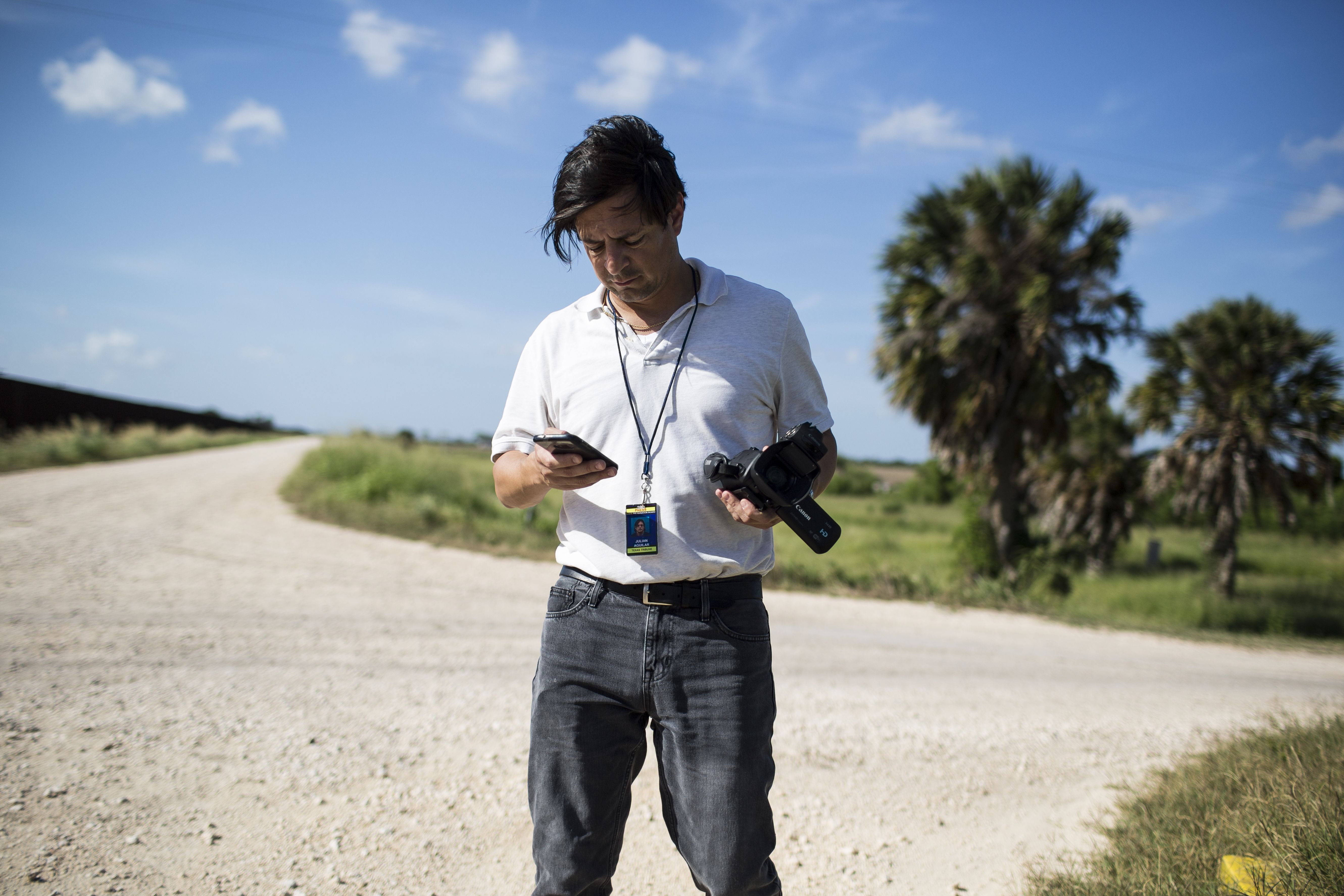 Julián Aguilar reporting near the border fence in Cameron County, Texas. Image by Martin do Nascimento. United States, 2017.