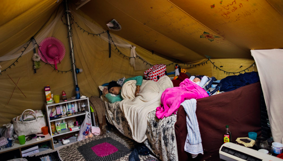 Nour rests with baby Rahaf in their tent on Nov. 7, less than a week after she was born. Image by Lynsey Addario for TIME. Greece, 2016.