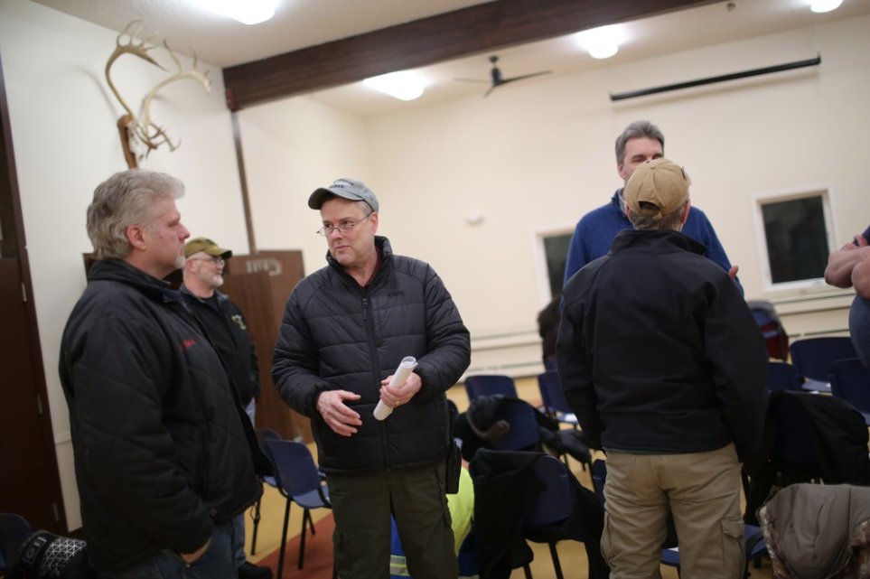 In this Feb. 18, 2019, photo, Nome, Alaska police chief Robert Estes, center, speaks to other attendees at a community public safety meeting. In 2019, Estes launched an internal cold case audit that uncovered evidence that the agency regularly failed to fully investigate sexual assaults. But in October, he resigned his post, saying the city failed to provide enough resources to continue the case audit or police the city on a daily basis. Image by Wong Maye-E. United States, 2019.