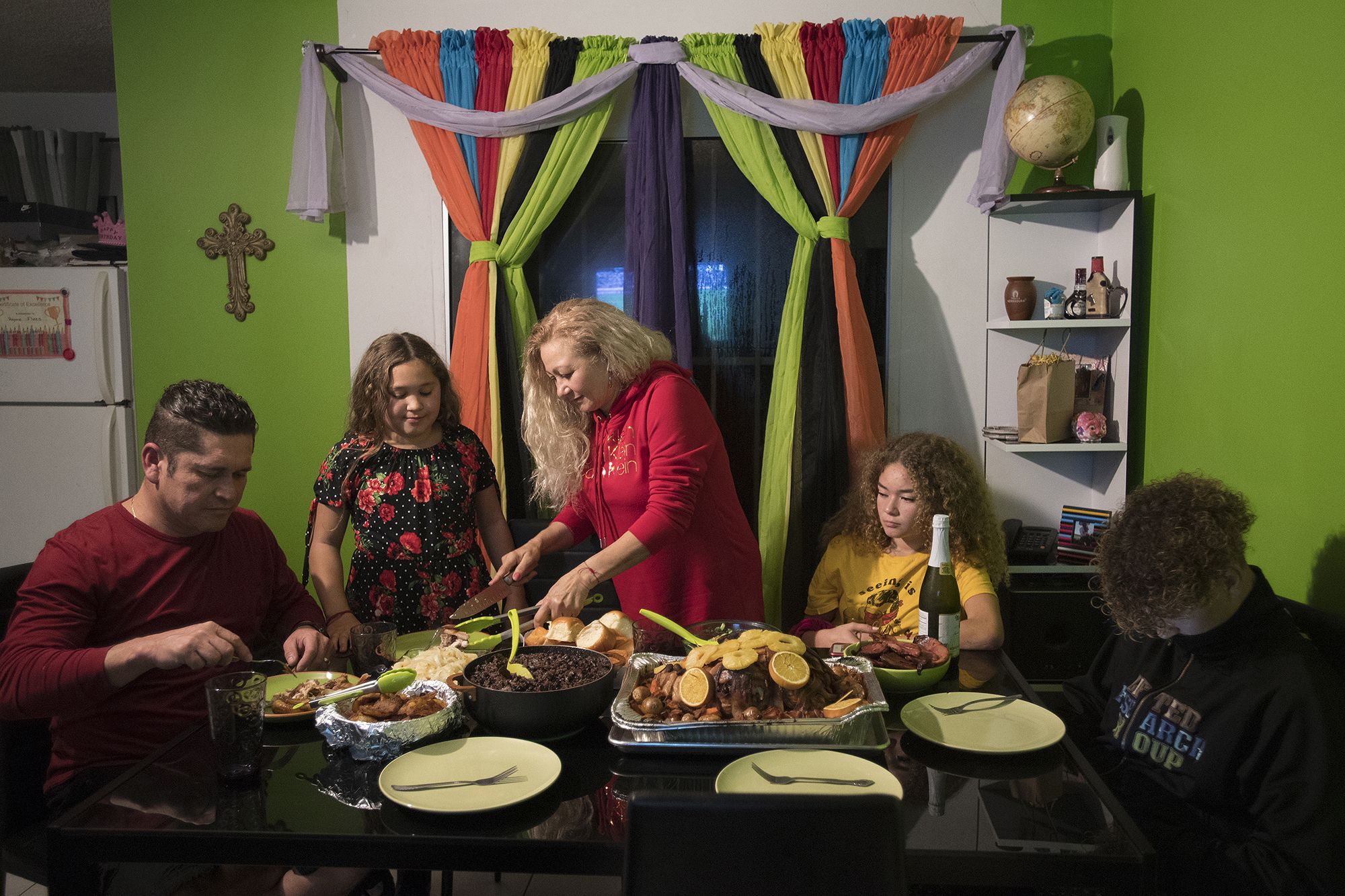 Ramon Flores, 46, from left, formerly of Hazel Dell, sits down to Thanksgiving dinner at his apartment in Tijuana, Mexico, with his daughter, Rayma, 10, wife, Enedis, 54, daughter, Kennedy, 16, and son, Raymond, 15. His family, who now lives in Chula Vista, Calif., crossed the U.S.-Mexico border shortly before midnight Wednesday so they could be together for the American holiday. Image by Amanda Cowan. Mexico, 2019.