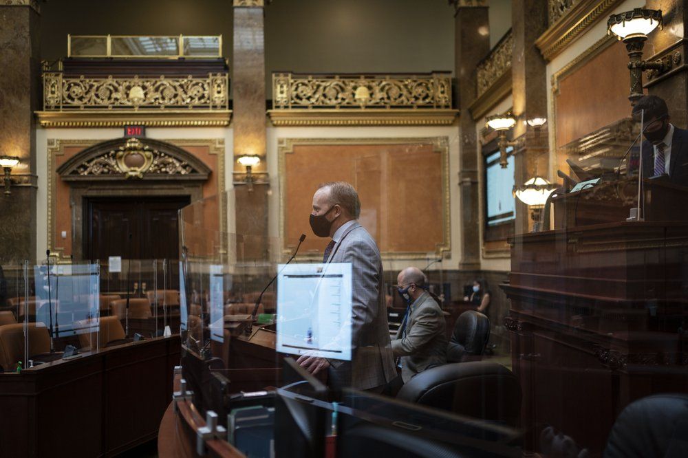 Surrounded by coronavirus barriers, staff members test the sound system of the House chamber of the Utah State Capitol in Salt Lake City. Tuesday, Nov. 17, 2020. When it comes to politics, Utah has long claimed things are different here. Political viciousness is for other places, many politicians will tell you. Legislators are more polite, more willing to compromise. The deep conservativism, the folklore says, includes a powerful strain of compassion. Image by Wong Maye-E / AP Photo. United States, 2020.