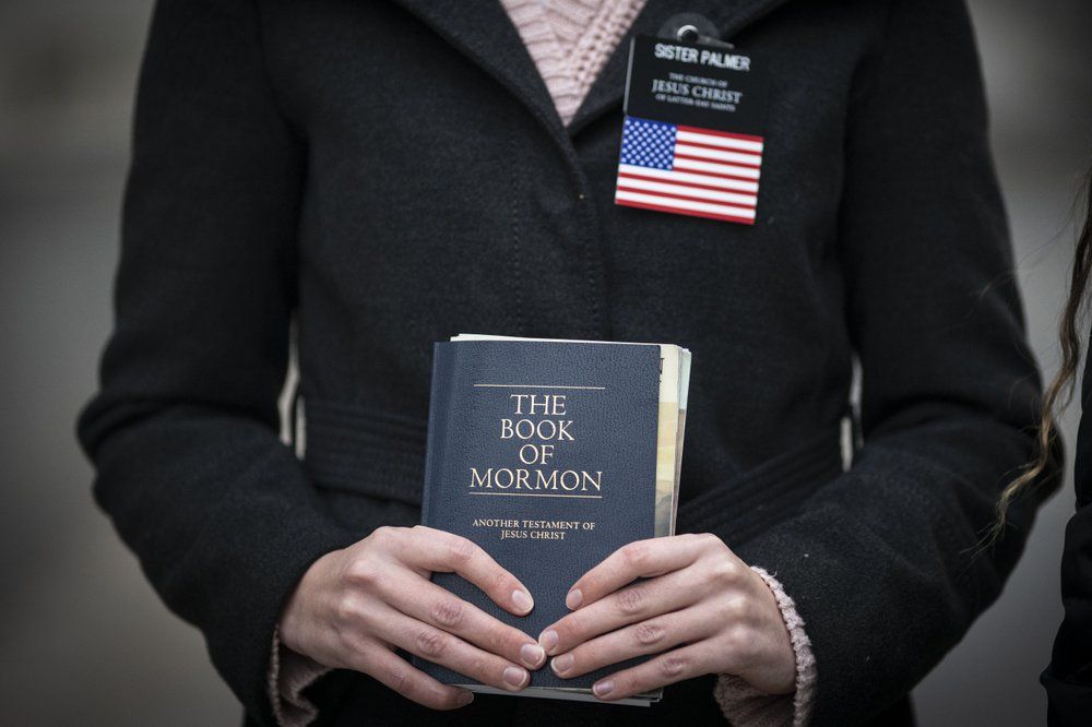 Sister Palmer, 19, holds The Book of Mormon while walking around Temple Square in Salt Lake City, Sunday, Nov. 15, 2020. Palmer, a member of The Church of Jesus Christ of Latter-day Saints, is serving an 18-month mission in Salt Lake City while waiting for her visa to continue the mission in Spain. Image by Wong Maye-E / AP Photo. United States, 2020.