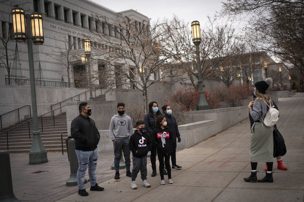 Members of The Church of Jesus Christ of Latter-day Saints speak to tourists around Temple Square in Salt Lake City, Sunday, Nov. 15, 2020. While the church has traditionally been overwhelmingly conservative and Republican, today there's also an increasingly large strain of liberal members. The church has also begun to directly address its history of racism, including a ban on Black priests that it lifted four decades ago. Image by Wong Maye-E / AP Photo. United States, 2020.