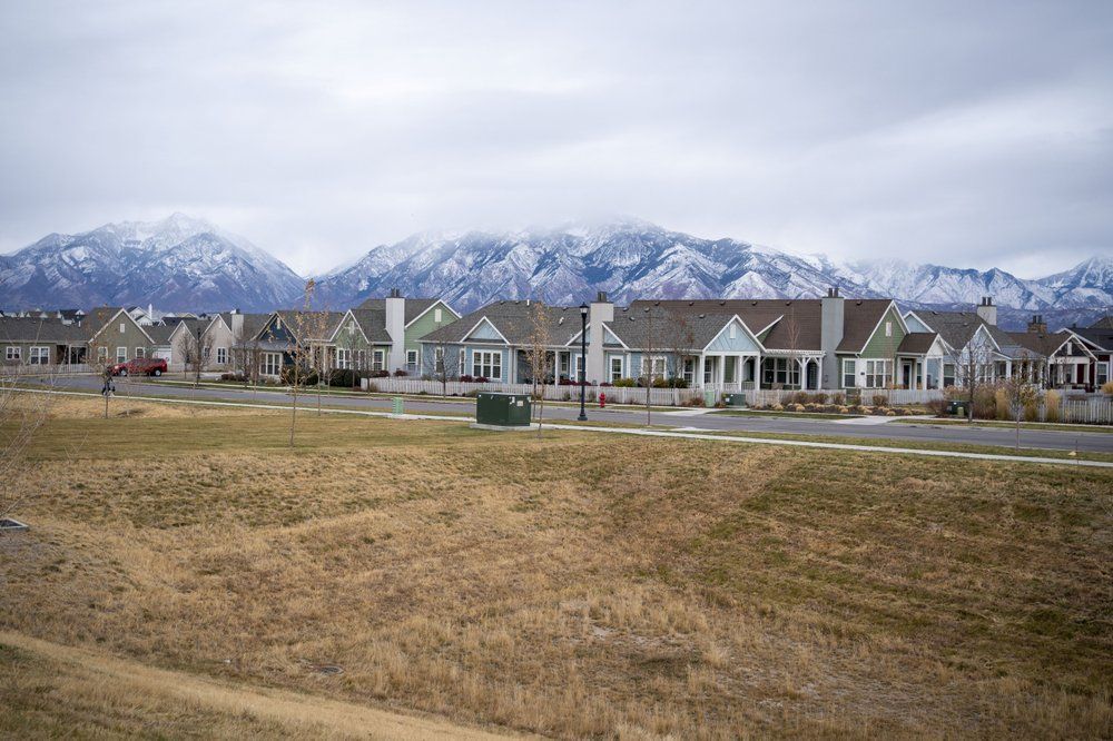 Homes line up against the backdrop of snow capped mountains in South Jordan, Utah, Sunday, Nov. 15, 2020. Founded by believers in what was then a small, fringe religion, Utah was then lost in the desolation of mountains and deserts, and viewed with suspicion by much of America. The insularity that resulted has been fading over the past few decades, but it's still a place intensely proud of its own distinctiveness. Image by Wong Maye-E / AP Photo. United States, 2020.