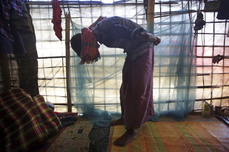 In this Monday, Nov. 27, 2017, photo, Mohamed Yaha, 18, demonstrates to The Associated Press in his tent in Jamtoli refugee camp in Bangladesh, what he saw when soldiers bound the hands of dozens of men behind their backs with nylon rope and blindfolded them with scarves taken from the women when they massacred his village Maung Nu, in Myanmar’s Rakhine State. More than 650,000 Rohingya Muslims have fled to Bangladesh from Myanmar since August, and many have brought with them stories of atrocities committed by security forces in Myanmar, including an Aug. 27 army massacre that reportedly took place in the village of Maung Nu. Image by Wong Maye-E. Bangladesh, 2017.