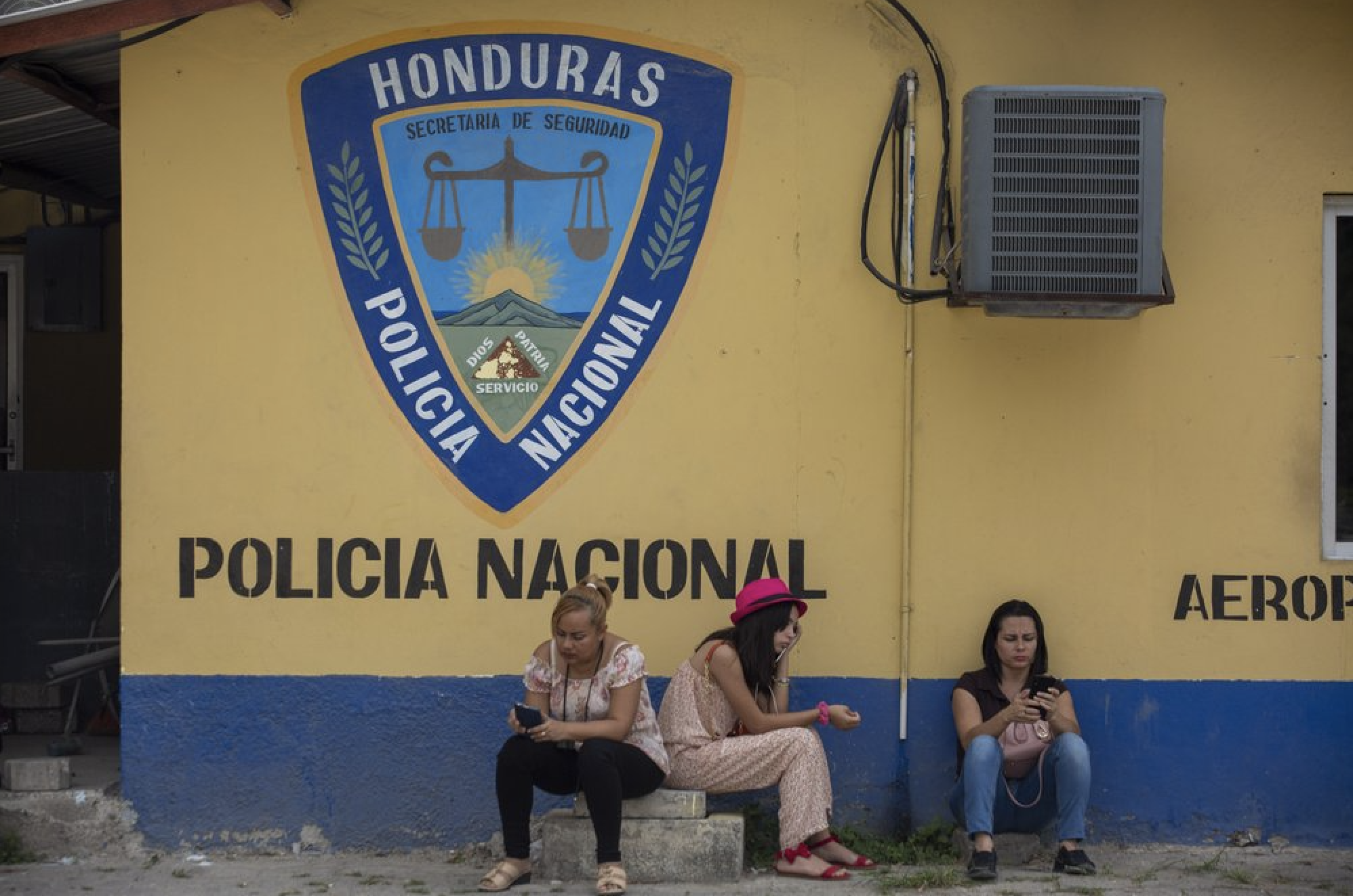 Family members wait outside the Ramon Villeda International Airport in La Lima, Honduras on Nov. 29, 2019, for the arrival of their relatives who were deported from the United States. Immigration apprehensions along the U.S.-Mexico border have plunged by more than 70 percent in the past six months, down sharply from at least 132,000 in May. Image by Moises Castillo/ AP Photo. Honduras, 2019.