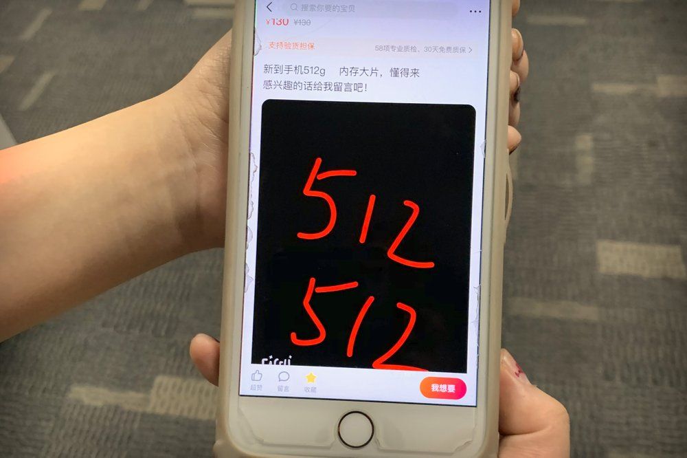 In this Dec. 24, 2019 photo, a post from a vendor offering Tylox for sale on Xianyu, Alibaba's online second-hand marketplace, is seen on a smartphone in Shanghai, China. Officially, pain pill addiction is an American problem, not a Chinese one. But people in China have fallen into opioid abuse the same way many Americans did, through a doctor's prescription. And despite China's strict regulations, online trafficking networks, which facilitated the spread of opioids in the U.S., also exist in China. Tylox pills are known on the black market as 512s, after the number marked on their side. The text of the ad reads "Newly arrived 512g cell phones, loaded with blockbuster movies, who understands come. If interested, leave me a message!". Image by Mark Schiefelbein/ AP Photo. China, 2019.