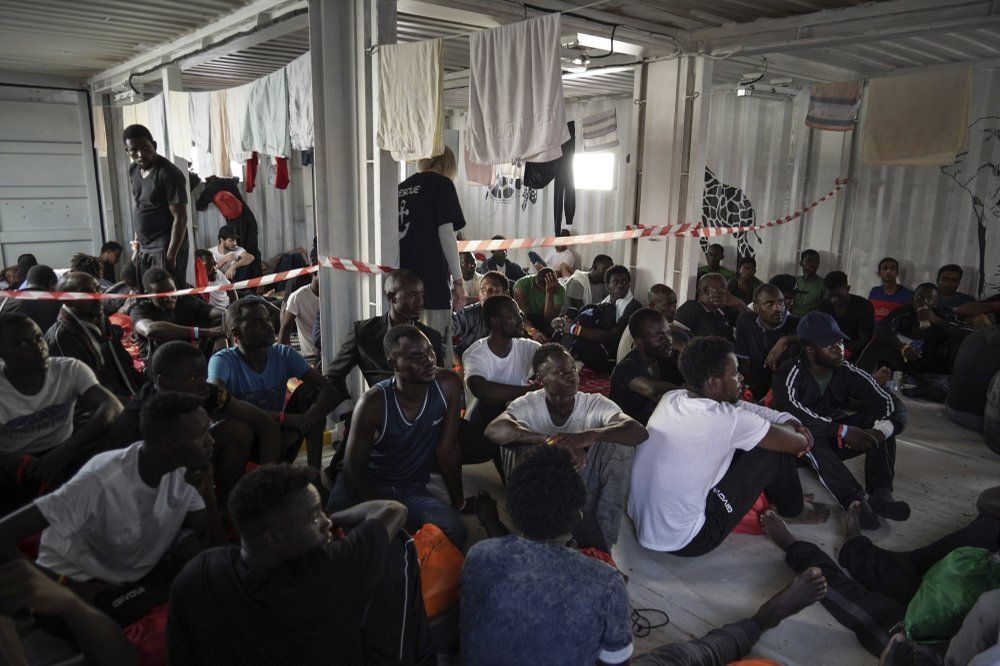 In this Sept. 18, 2019 photo, migrants rescued at sea rest in the men's shelter aboard the Ocean Viking humanitarian ship as it sails in the Mediterranean Sea. The misery of migrants in Libya has spawned a thriving and highly lucrative business, in part funded by the EU and enabled by the United Nations, an Associated Press investigation has found. Image by Renata Brito/AP Photo. Libya, 2019.