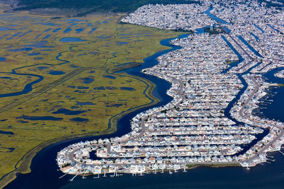 The subdivision Beach Haven West was carved out of a New Jersey salt marsh beginning in 1945. The passage of the state Wetlands Protection Act of 1970 prevented additional loss of wetlands in New Jersey. Scientists with Rutgers University in New Jersey forecast a rise of sea level along the state’s shoreline of as much as 106 centimeters by 2100. That would inundate a large percentage of this community of almost 4,000 people. Image by Alex MacLean. United States, 2019.
