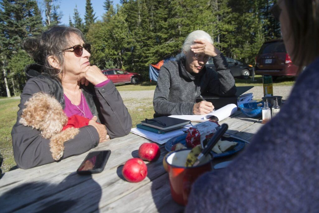 Roberta Benefiel-Frampton, left, discusses a plan for protesting the NorthEast Governors and Premiers meeting with Meg Sheehan, director of the North American Megadams Resistance Alliance, at New River Beach Provincial Park in Lepreau, New Brunswick, Canada, on Sept. 8, 2019. Image by Michael G. Seamans. Canada, 2019.