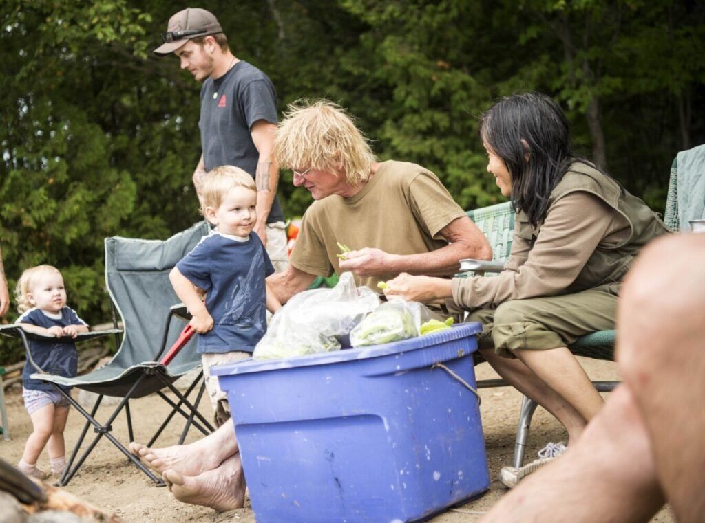Duane Hanson greets his grandson, Jensen, while snapping green beans with Sally Kwan at Spencer Lake in T3 R5, in the Unorganized Territories of Maine, on Aug. 3, 2019. Image by Michael G. Seamans. United States, 2019.