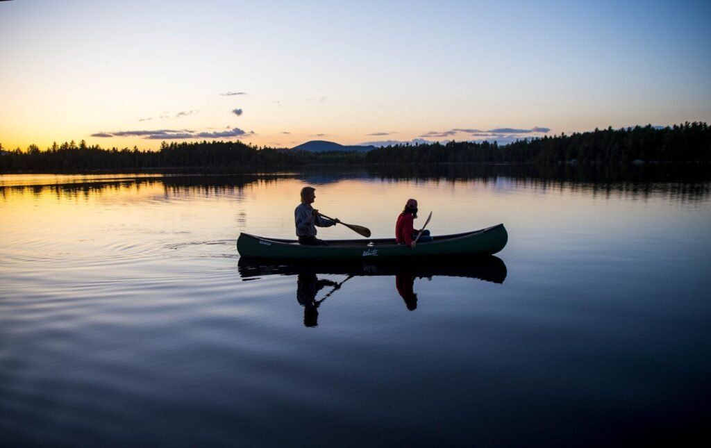 Duane Hanson and Sally Kwan paddle on Whipple Pond at their homestead in the Unorganized Territories in the north woods of Maine near T5 R7 on May 27, 2019. Image by Michael G. Seamans. United States, 2019.