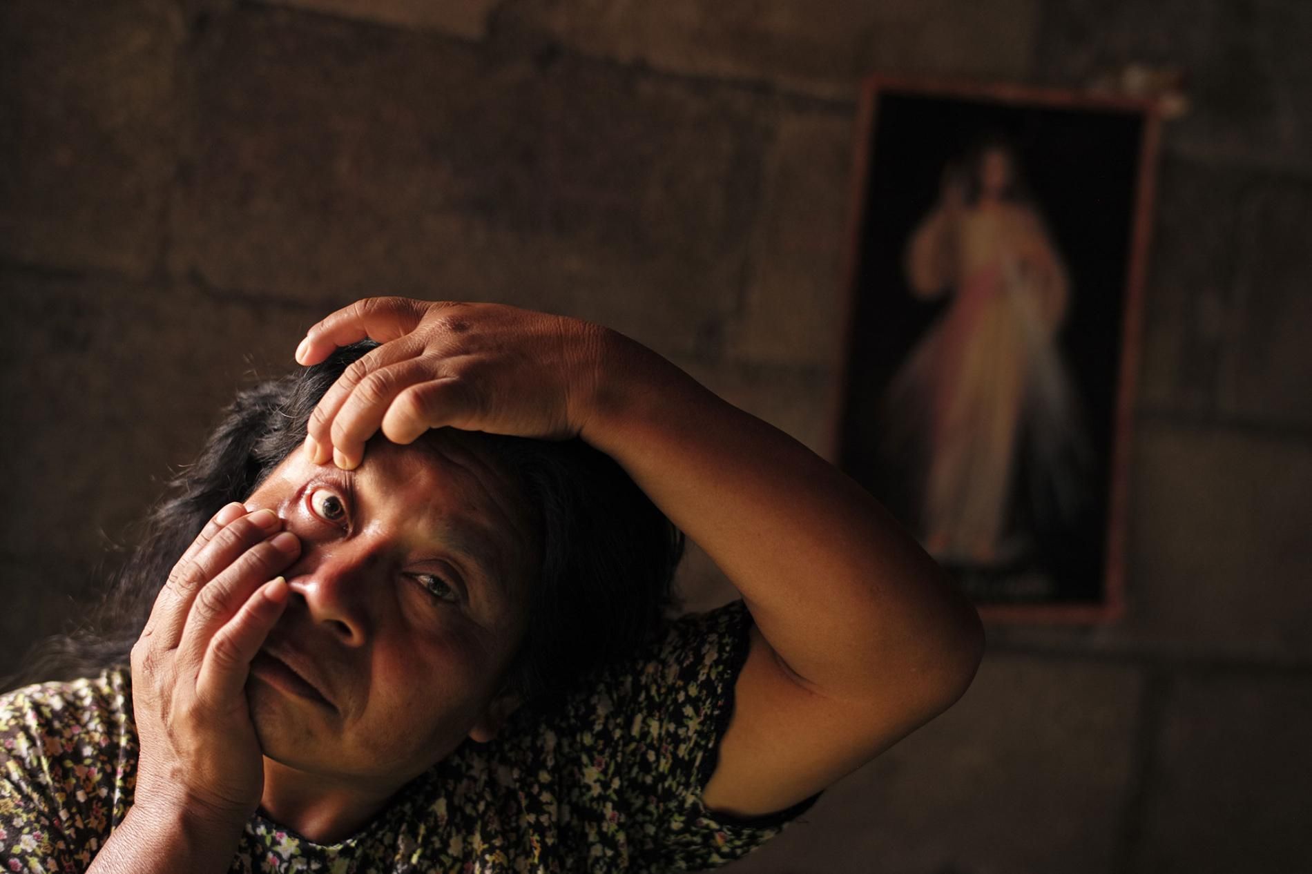 But the López family's new stove is unventilated, so the smoke still pours into the kitchen, where Tania's mother and grandmother also do their weaving. Her grandmother Augustina has swollen, burning eyes. Image by Lynn Johnson. Guatemala, 2017.