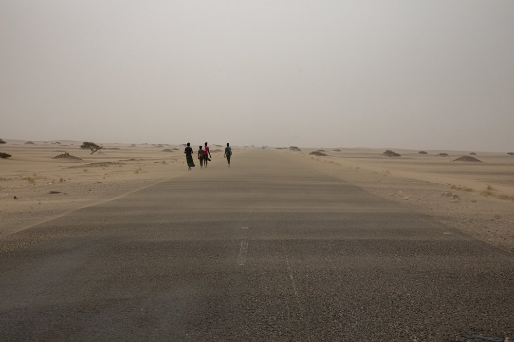 Ethiopian migrants walk along a road in a sandstorm. Image by Nariman El-Mofty. Yemen, 2019.