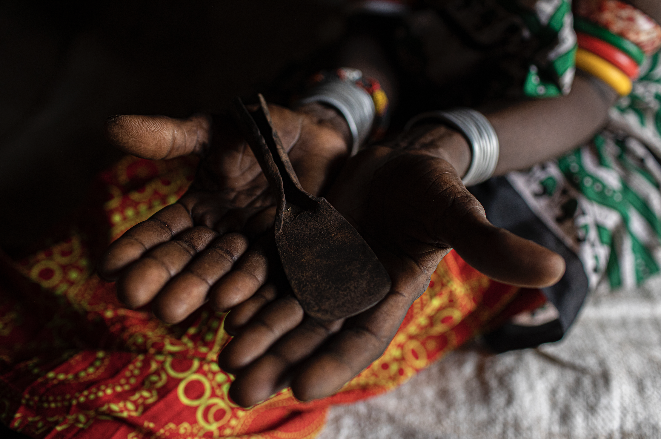 Christine Lemowonapi, a former Rendille circumciser, holds a tool she once used to perform FGC at her home in Merille, Kenya. Image by Will Swanson. Kenya, 2020.