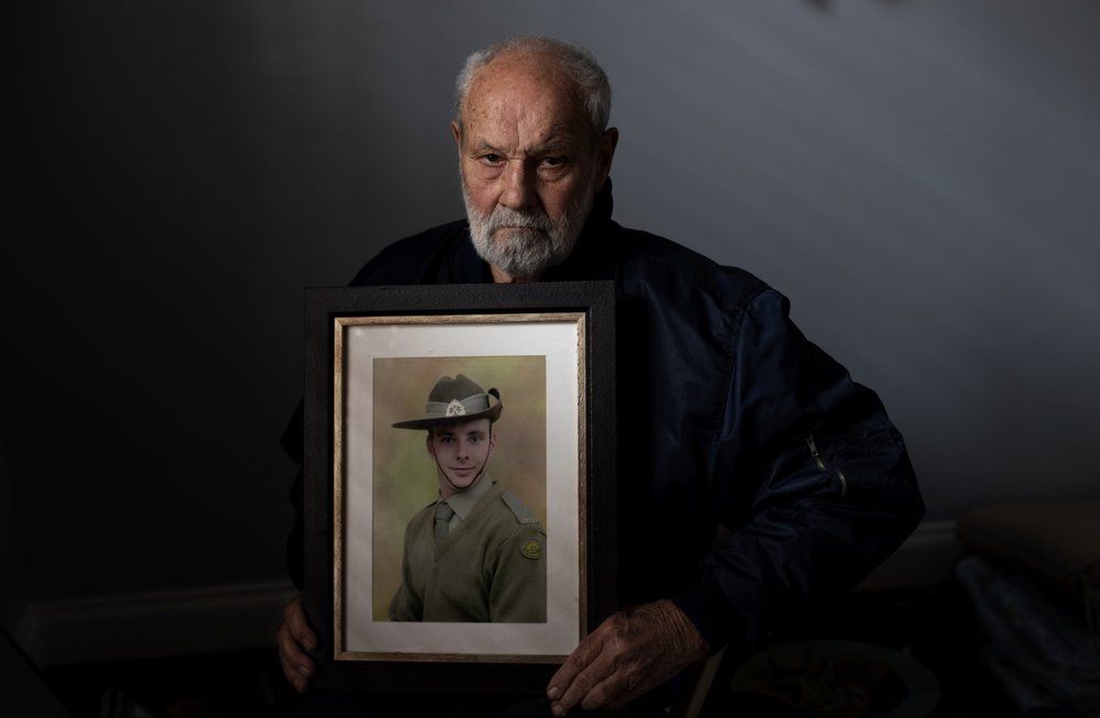 David Tonkin holds a photo of his late son, Matthew, in his room at their home in Perth, Australia, Sunday, July 21, 2019. The addiction that ultimately ended Matthew's life began in 2012, after he was injured during a training session while serving with the Australian army in Afghanistan. The pills had been prescribed to him by American doctors in Afghanistan. Image by David Goldman. Australia, 2019.