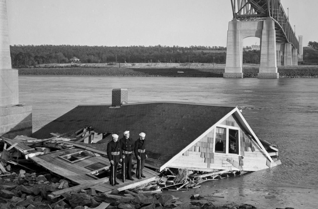 1938: Soldiers guarded a house that was blown into the Cape Cod canal under the Bourne Bridge during the hurricane. Image courtesy of Boston Public Library, Leslie Jones Collection. United States, 1938.