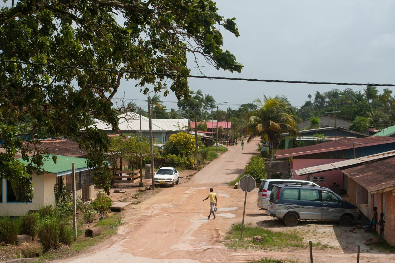 A man walks through a neighborhood in Moengo, Suriname, built by Alcoa's subsidiary for its employees. Image by Stephanie Strasburg. Suriname, 2017.
