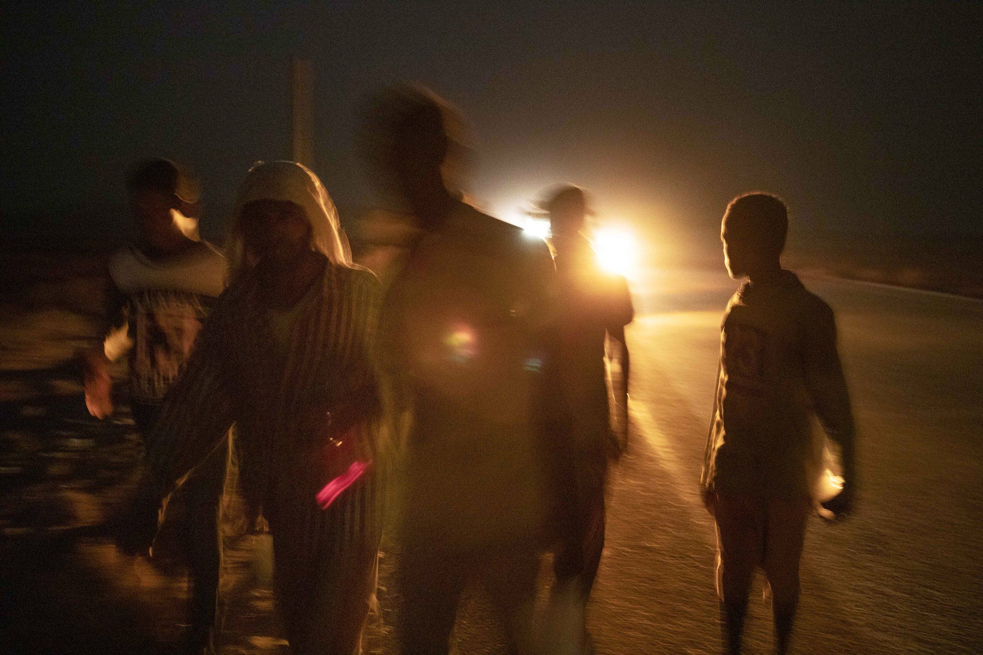 Mohammed Eissa, second left, walks on a highway with boys he met on the way, around 50 kilometers (31 miles) from Djibouti. Image by AP Photo/Nariman El-Mofty. Djibouti, 2020.