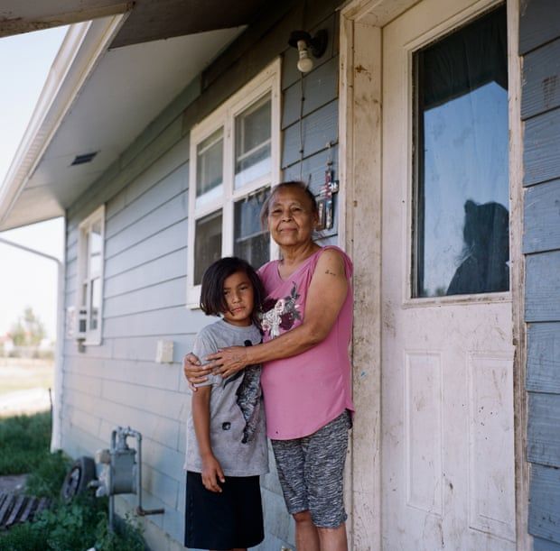 Valerie Whitehawk, 61, and her granddaughter, Macylilly, eight, outside of their home on Fort Peck Indian Reservation. Image by Sara Hylton. United States, 2019.