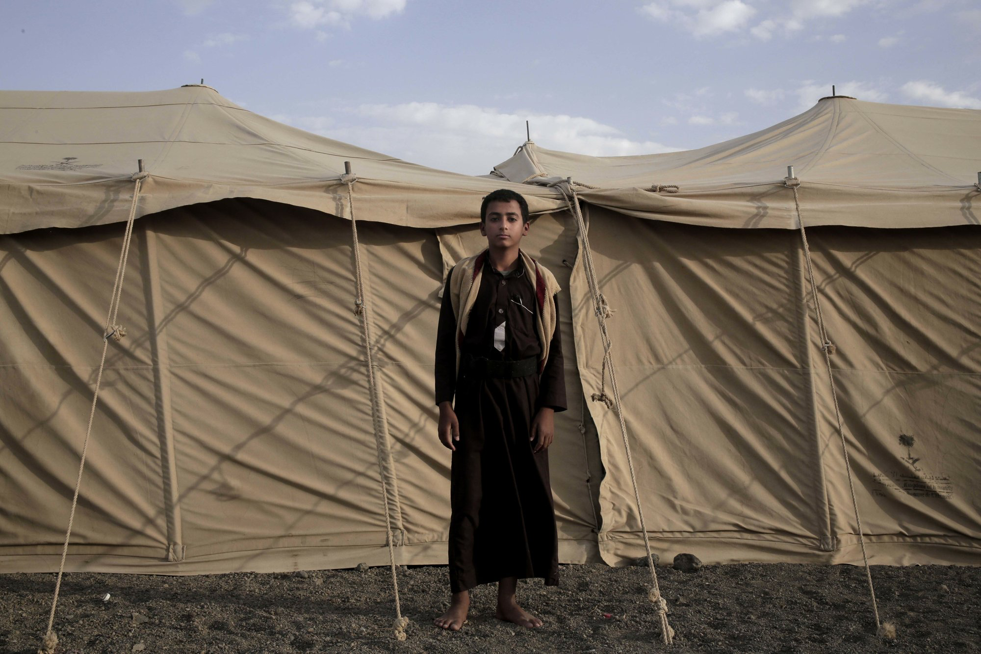 Sadek, a 14 year-old former child soldier, poses for a photograph at a camp for displaced persons where he took shelter with his family, in Marib, Yemen, in this July 27, 2018, photo. Houthi rebels plucked him from his home and promised he would only run supplies to adult fighters, but it wasn’t long before he found himself deployed to fight on the front lines of Yemen's civil war. Image by Nariman El-Mofty / AP News. Yemen, 2018.