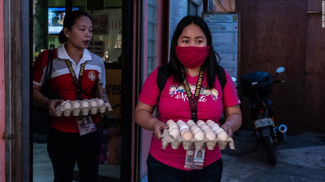 Rosalie Natividad wears a makeshift mask as she carries eggs to local families. Image by Xyza Cruz Bacani. Philippines, 2020.