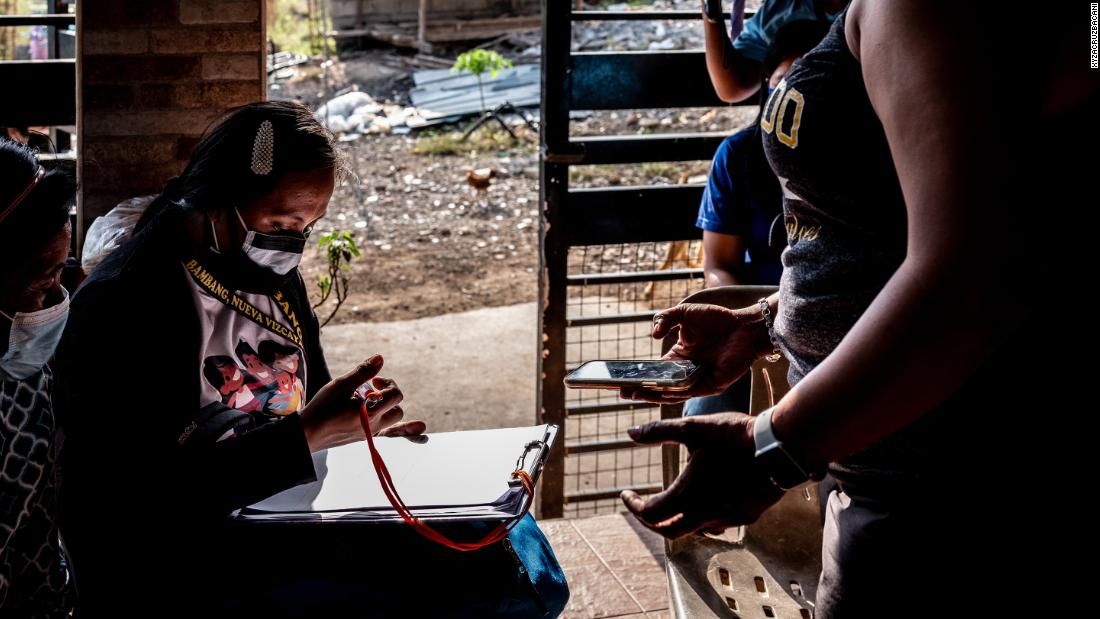 April Abrias writes her assessment of Joan Santos, a nurse from the United States who is under home quarantine. Image by Xyza Cruz Bacani. Philippines, 2020.