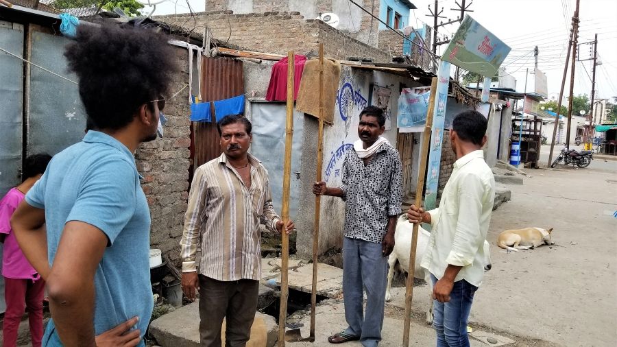 Suraj Yengde speaks with local sewer workers in Nanded. Hundreds of such workers, almost all Dalit, have died in accidents across the country, largely from breathing in dangerous fumes and slipping and falling in the dark. Image by Phillip Martin/WGBH. India, 2019.