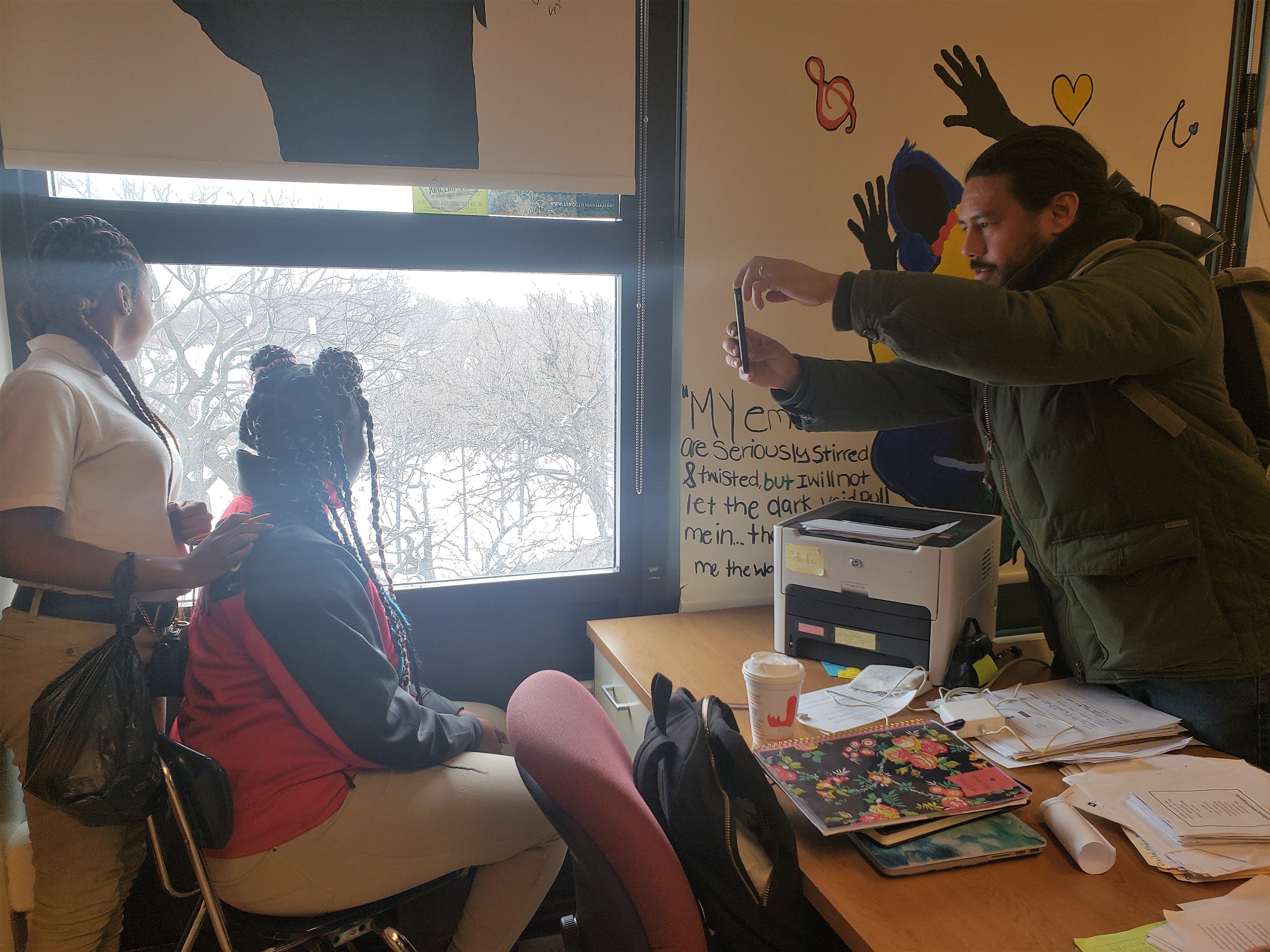 Brian Frank holds an impromptu photo shoot with students at North Lawndale College Prep on Chicago's west side. Image by Keta Glenn. United States, 2018.