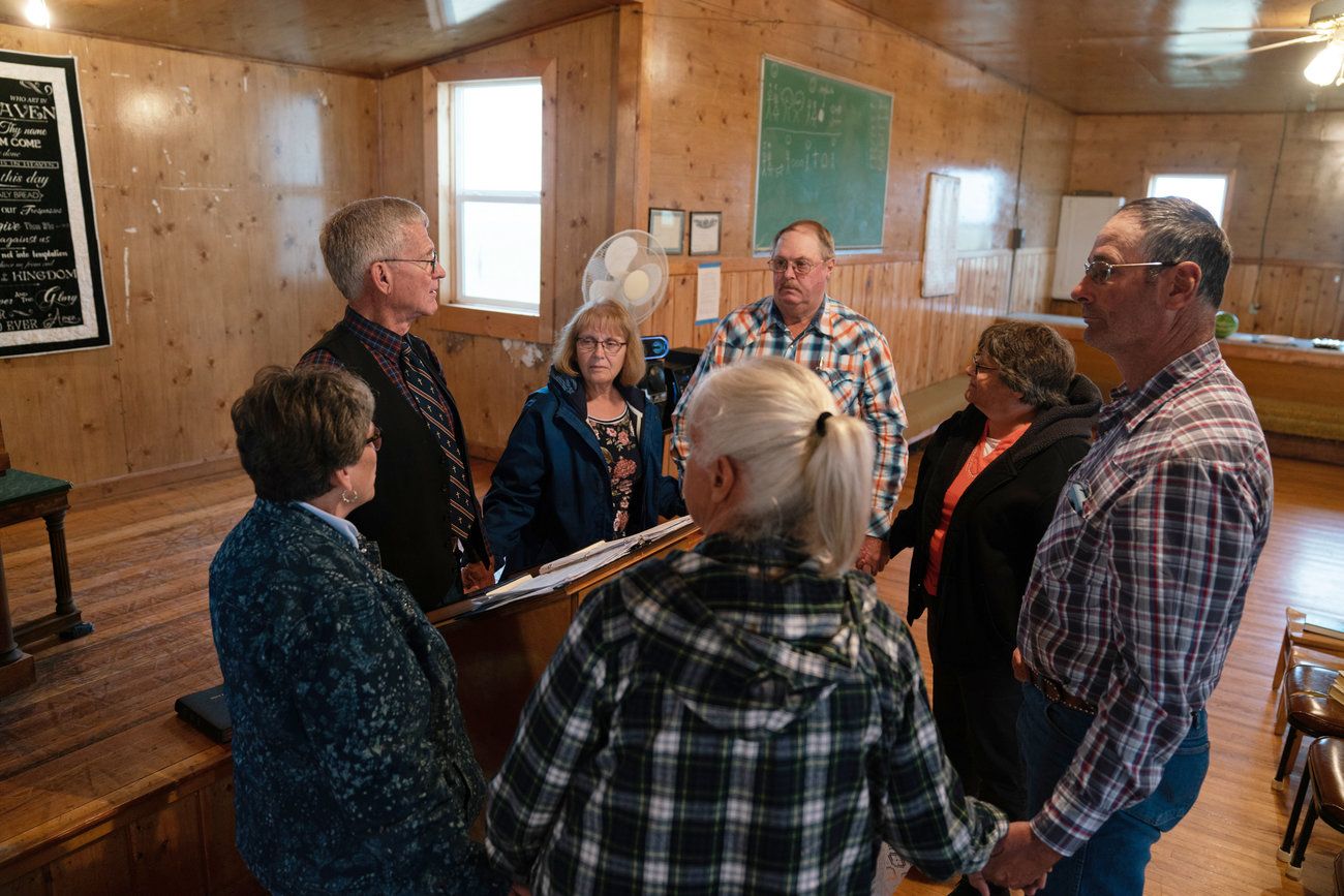 Ranchers gather with traveling pastor Hal DeBoer for a religious service at First Creek Community Hall. Image by Claire Harbage / NPR. United States, 2019.