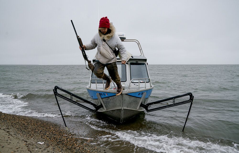 Vebjørn Aishana Reitan, polar bear guide and certified U.S. Coast Guard captain, dismounting his boat. Image by Nick Mott. United States, 2019.