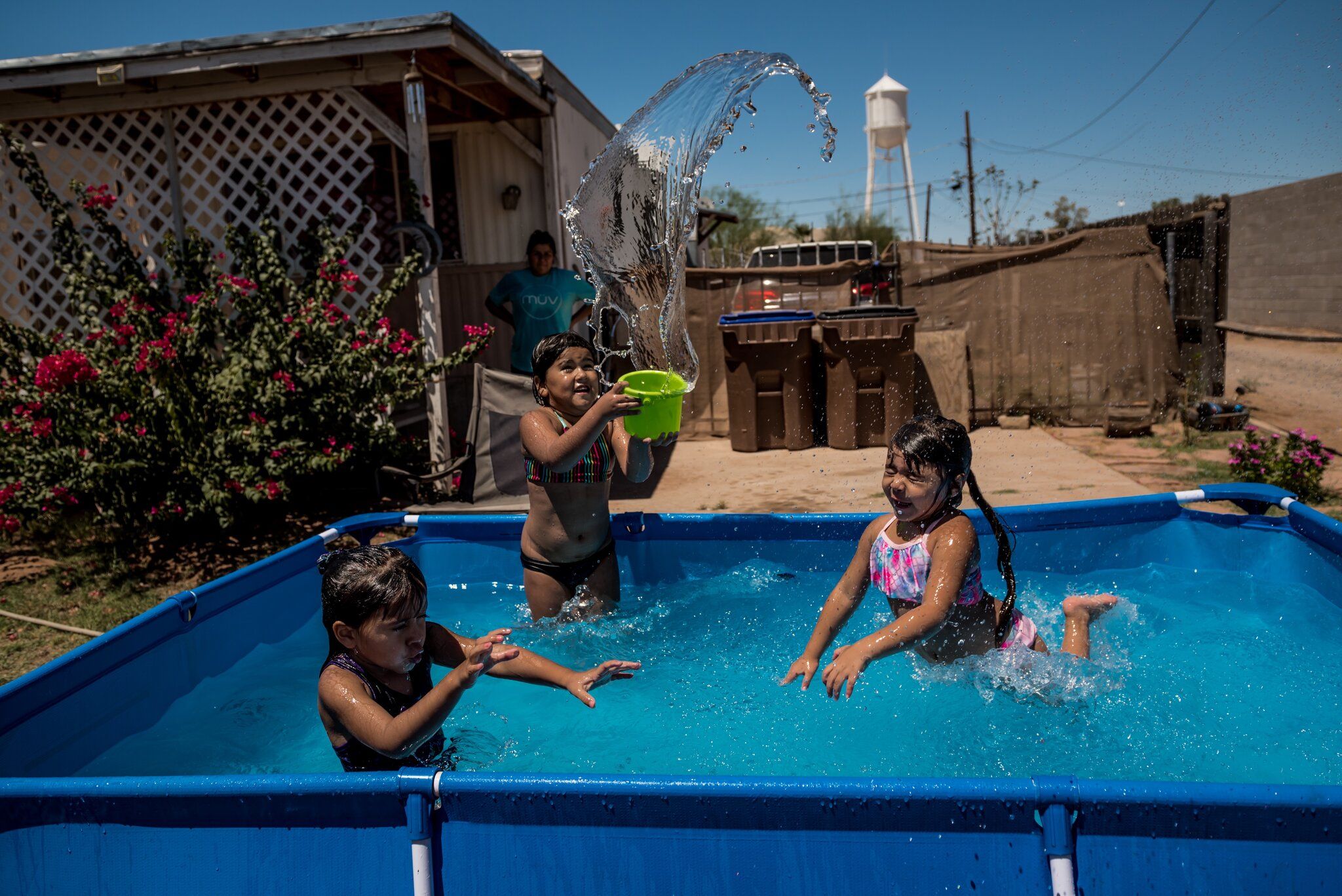 COOLIDGE, ARIZ. Marisela Felix set up a pool to keep her daughters and niece cool during 108-degree heat. Image by Meridith Kohut. United States, 2020.