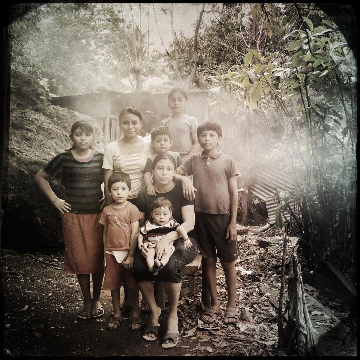 Nancy López surrounded by her children. The family has an EcoComal plancha stove that is vented but they are surrounded by their neighbor’s smoke. There is no escape. Image by Lynn Johnson. Guatemala, 2017.