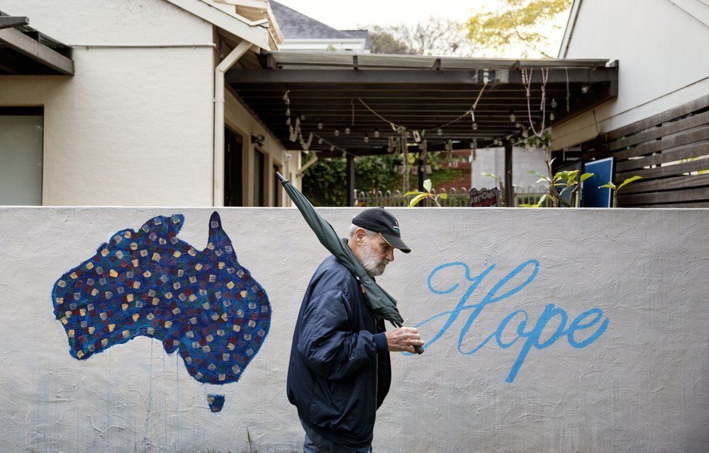 David Tonkin walks past a mural decorated with the map of Australia and the word "Hope," in his neighborhood in Perth, Australia, Sunday, July 21, 2019. His son, Matthew, who died from a drug overdose, hopped from clinic to clinic, collecting prescriptions for opioids and benzodiazepines, used to treat anxiety. The doctors were largely oblivious to what he was doing because Australia has no national, real-time prescription tracking system. Image by David Goldman. Australia, 2019.