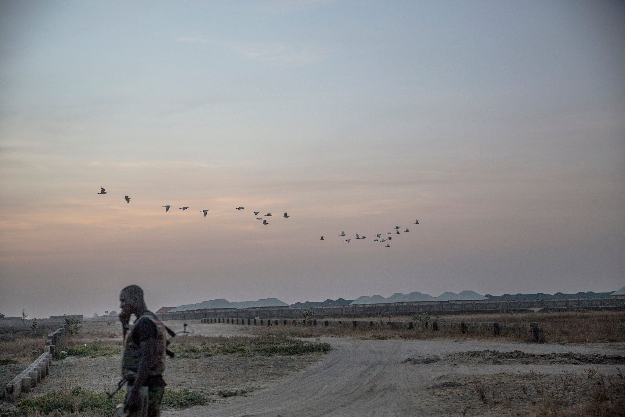 A soldier at dusk near a camp for displaced Nigerians on the edges of Maiduguri. Image by Glenna Gordon. Nigeria, 2017.