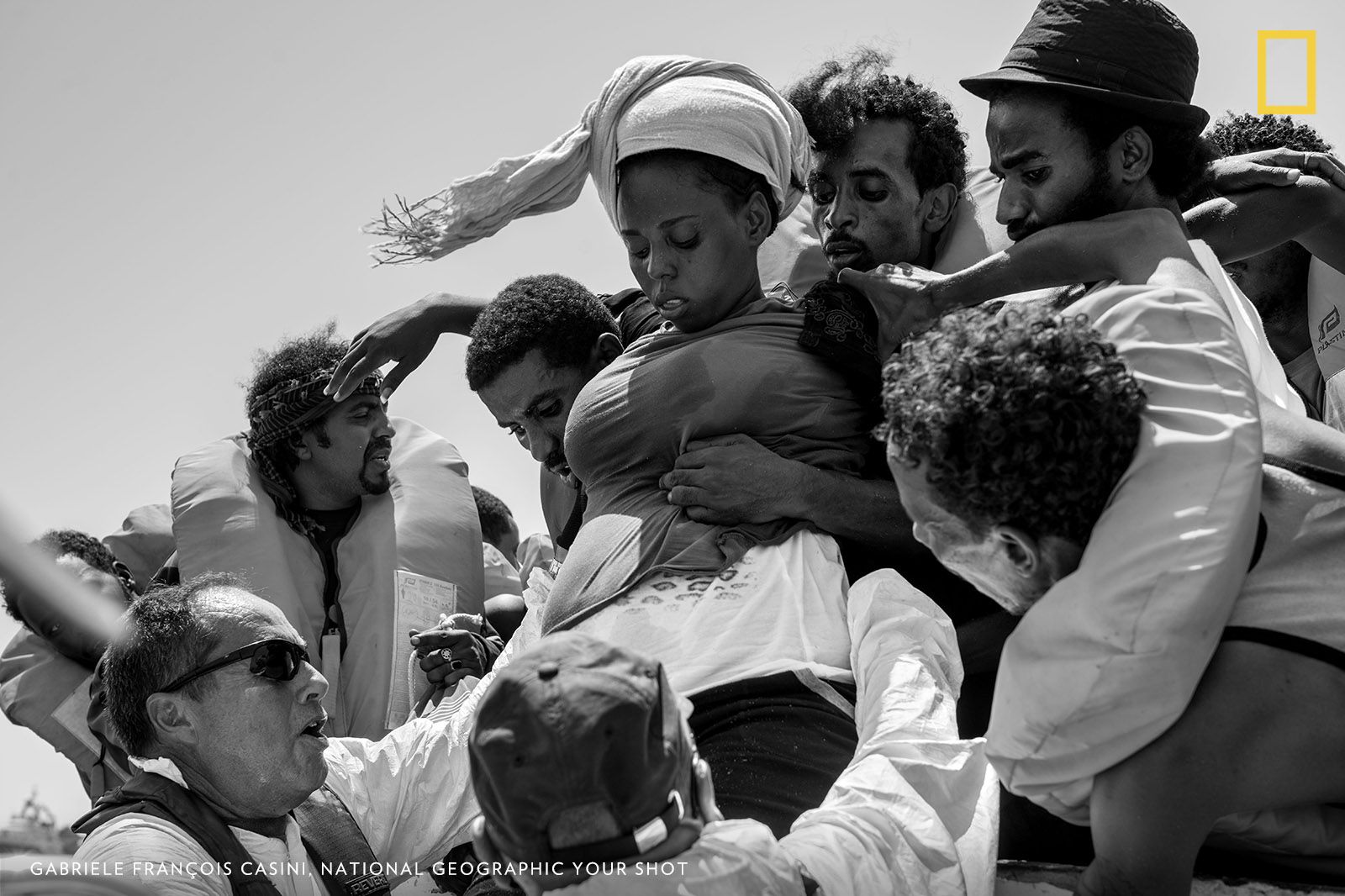 This photo was taken on a rescue boat in the Mediterranean Sea. A nine-month pregnant woman fainted because of heat and gasoline fumes from the engine of the dangerously overcrowded boat she was traveling on, in a desperate attempt to reach European shores. She took the incredibly hard decision to leave her home country, ruled by an oppressive regime, and embark on dangerous journey to guarantee a better future for her baby. She survived the crossing and gave birth few days later. Image by Gabriele Francois Casini.