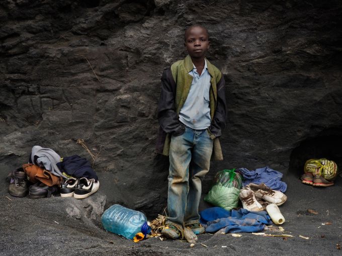 Brian Jovo, 14, stands in a small sheltered cove near the top of Kabwe's Black Mountain. Jovo helps his older brother at the mining site. Image by Larry C. Price. Zambia, 2017.