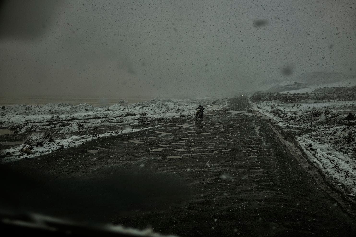 A miner on a motorcycle battles a springtime snow squall on his way back to the mine. It can snow 12 months out of the year, and miners work in harsh conditions 17,000 feet or higher. Peru, 2019. Image by James Whitlow Delano.